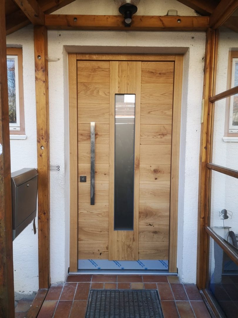 Eine Holztür mit Glaselementen und einem Briefkasten an der Seite