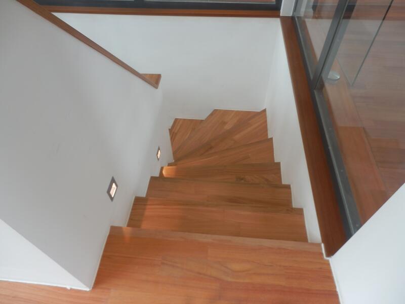 Eine Holztreppe mit einer Glaswand, die einen modernen und eleganten Raum schafft