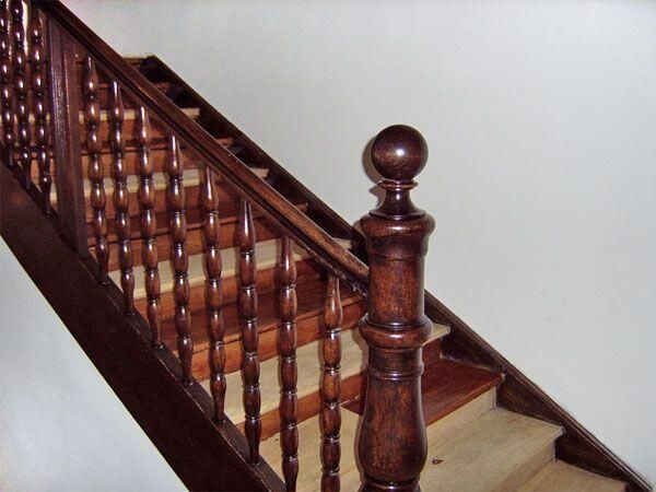 Eine Holztreppe mit einem Holzgeländer, die eine elegante und natürliche Atmosphäre vermittelt