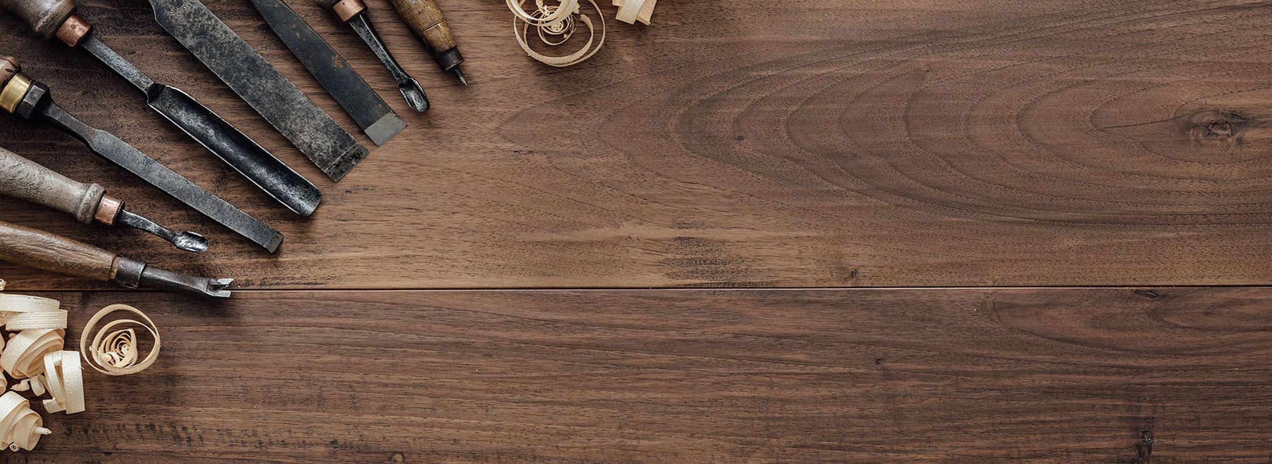 Verschiedene Holzwerkzeuge sind auf einem Tisch aus Holz angeordnet