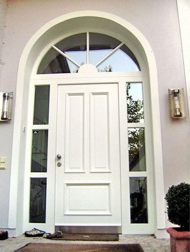 Ein weißes Haus mit einer großen Tür und mehreren Fenstern